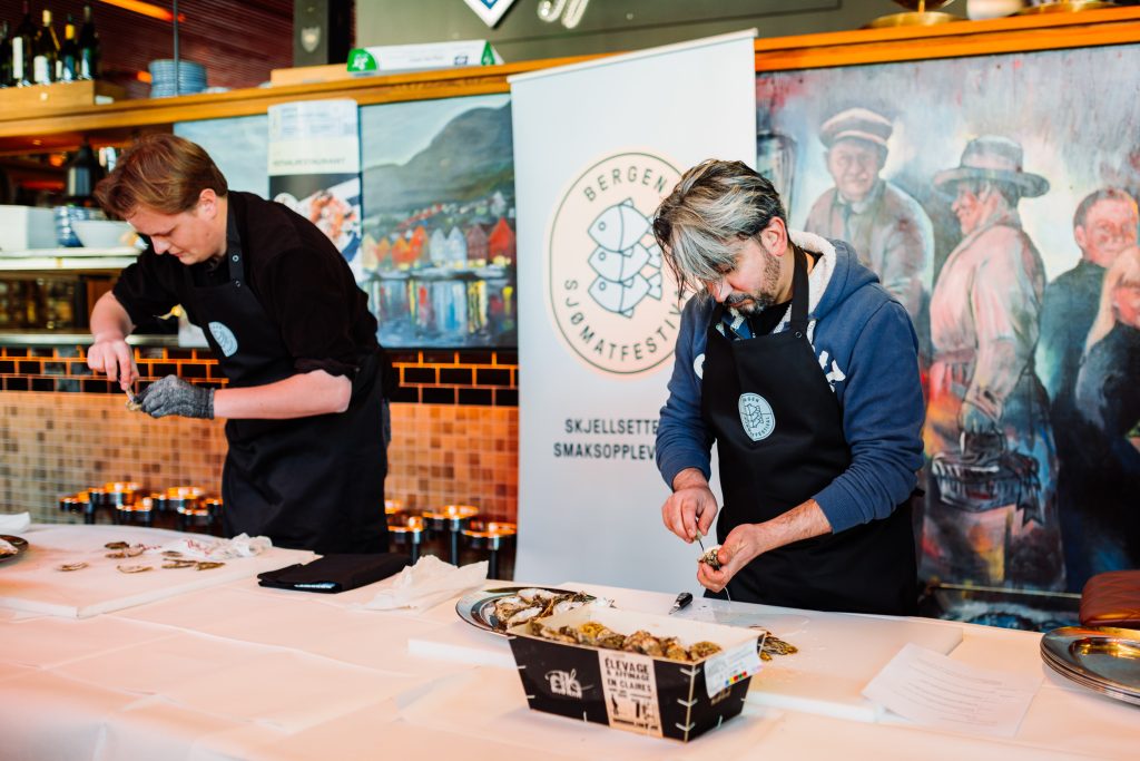 To menn som åpner østers i konkurranse