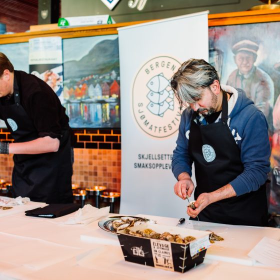 To menn som åpner østers i konkurranse
